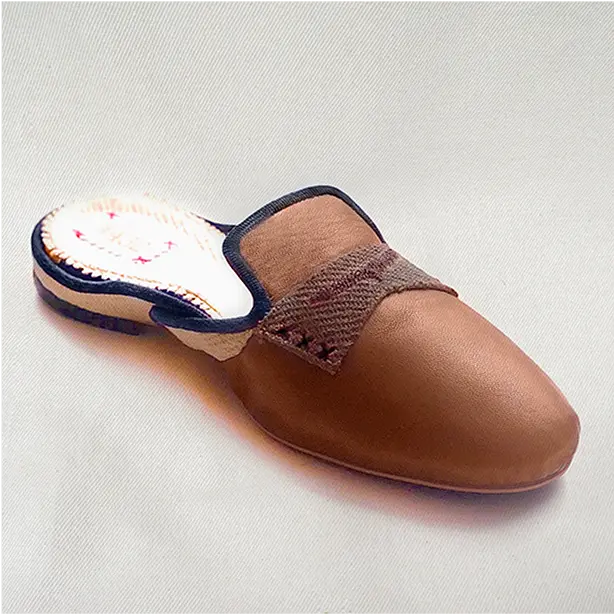 Close up view of a premium brown pair of genuine leather slippers with a soft inner lining.