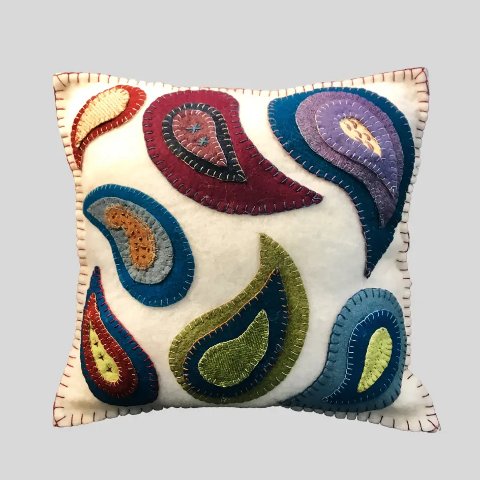 A decorative pillow with applique, incorporating layered fabric designs for a dimensional and artistic look.