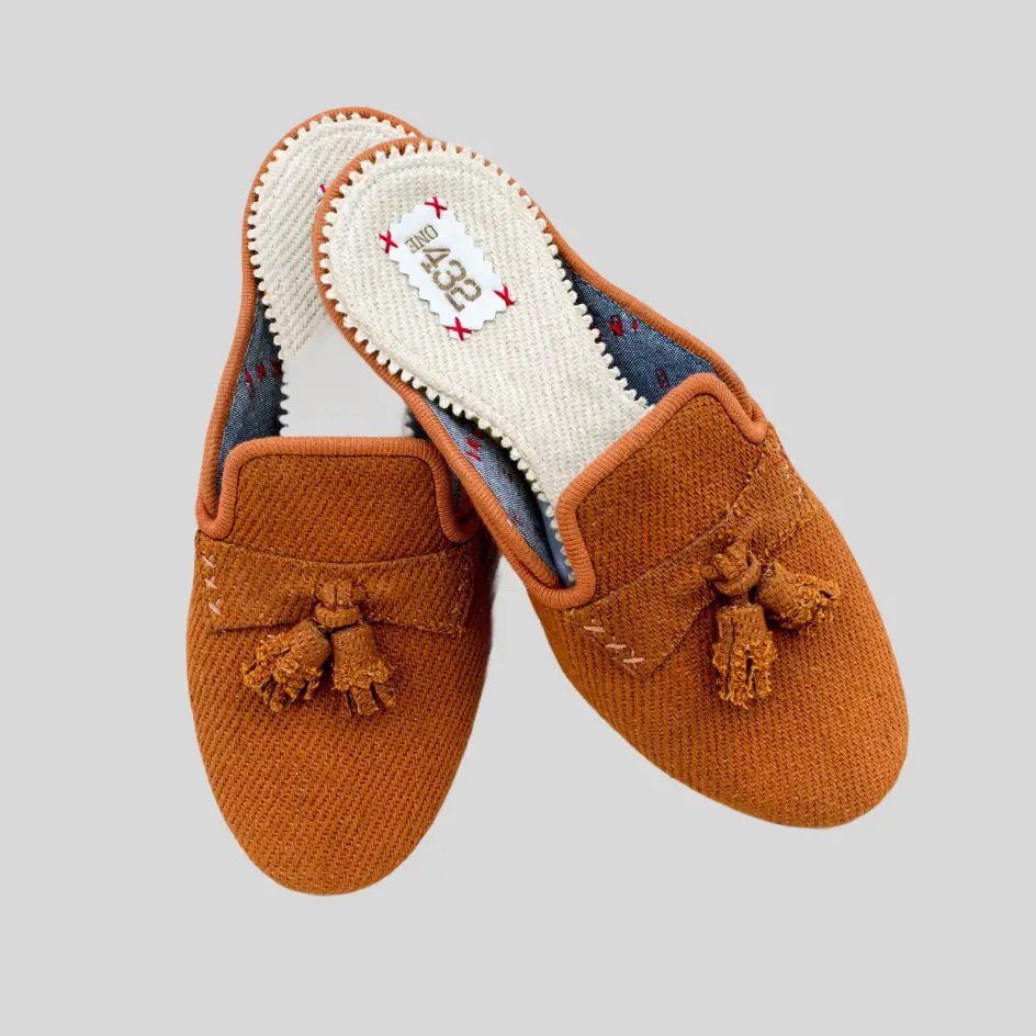 A pair of cotton slide slippers in a solid color, featuring a soft, breathable fabric with a minimalist and cozy design.