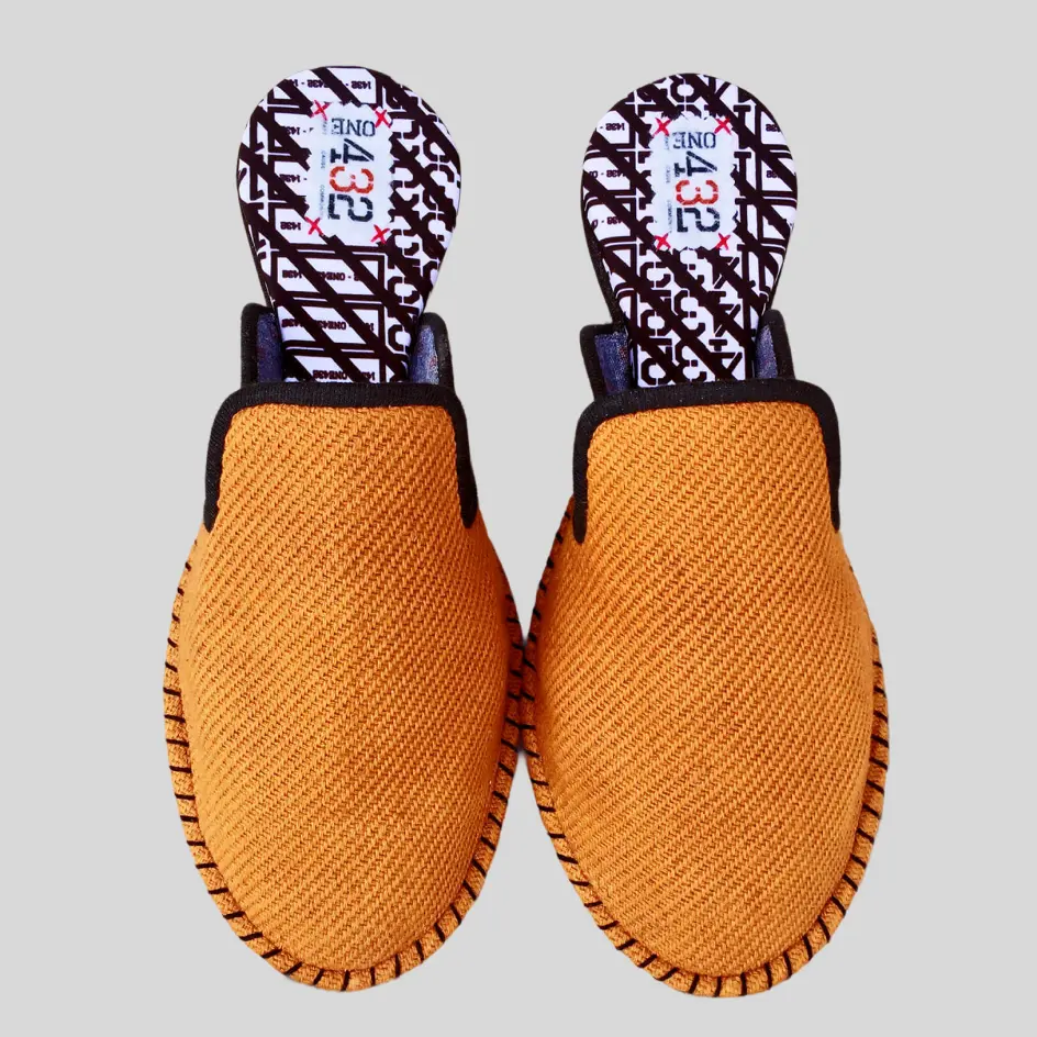 A close-up of cotton slide slippers with intricate embroidery, showcasing finely stitched patterns or monograms for a stylish and personalized touch.