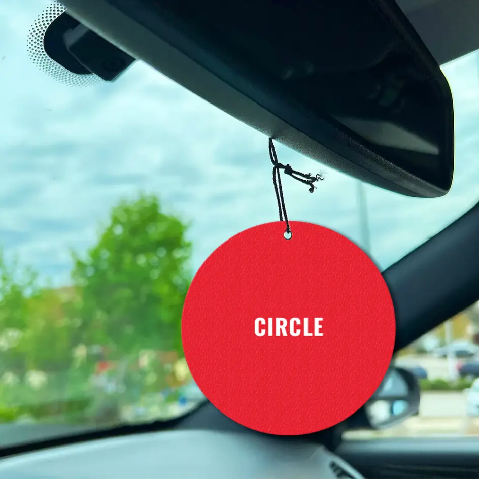 Circular air freshener with a smooth design and vibrant color print.