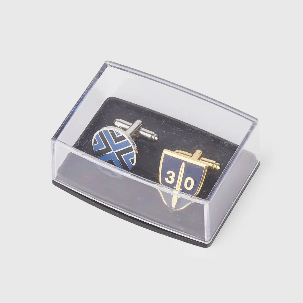 Set of two cufflinks in a clear presentation case, featuring shield and cross designs