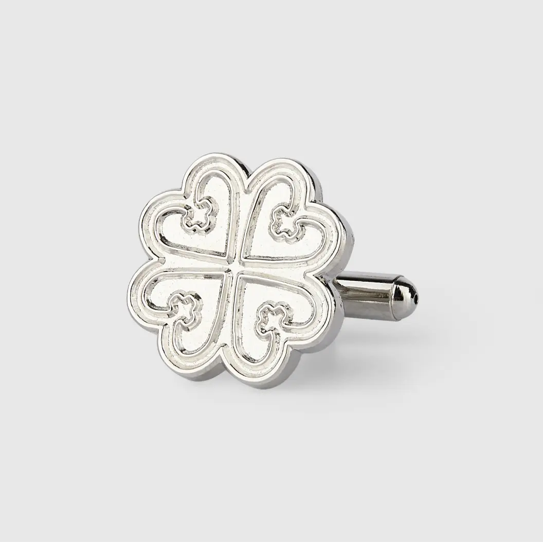 Silver cufflink with a clover-like design similar to a four-leaf clover