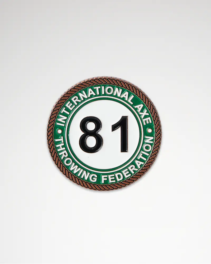 Green and white circular coin with the number “81” and “International Axe Throwing Federation.”