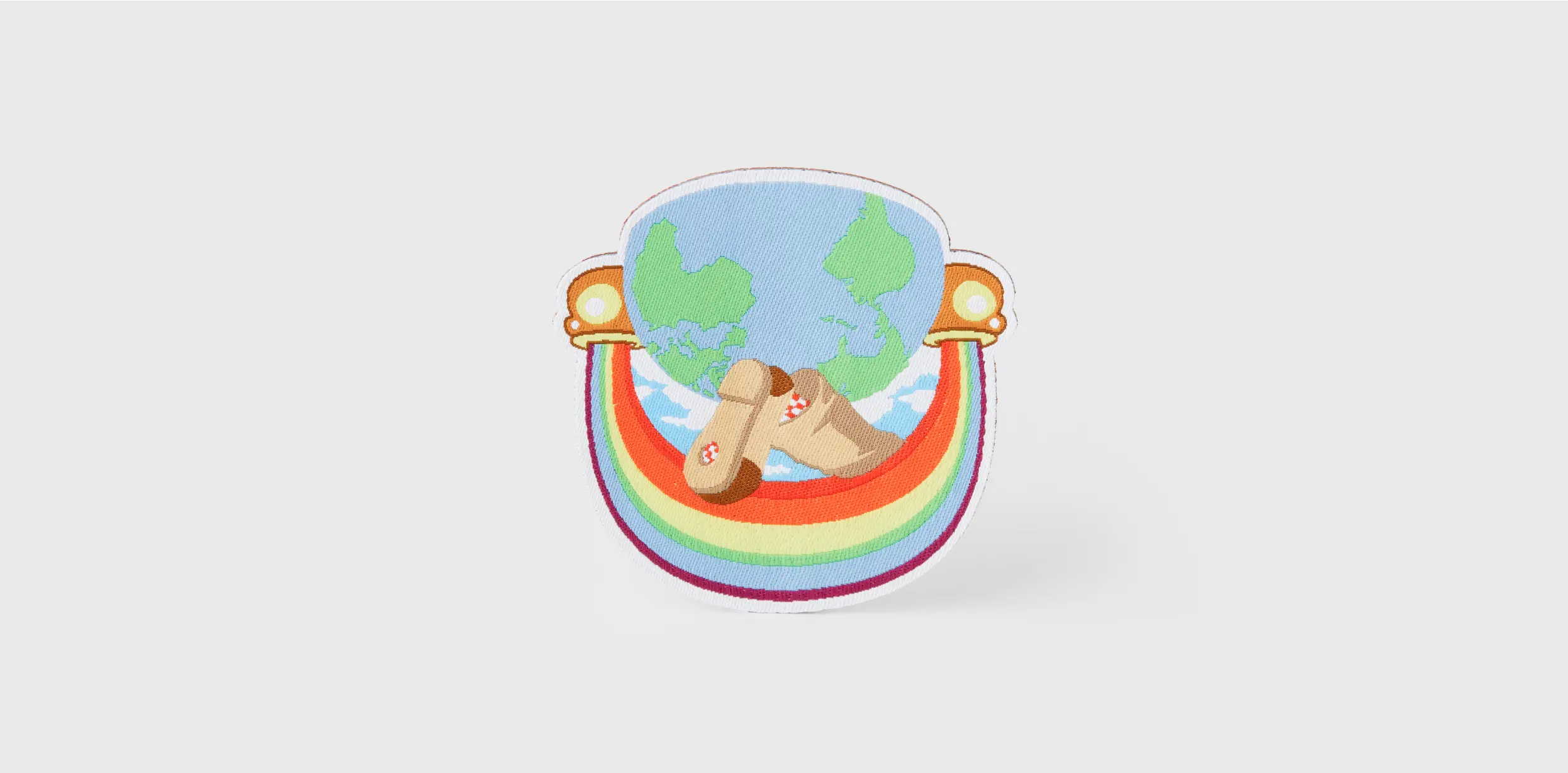 Custom woven patch with rainbow, world map, and clogs.