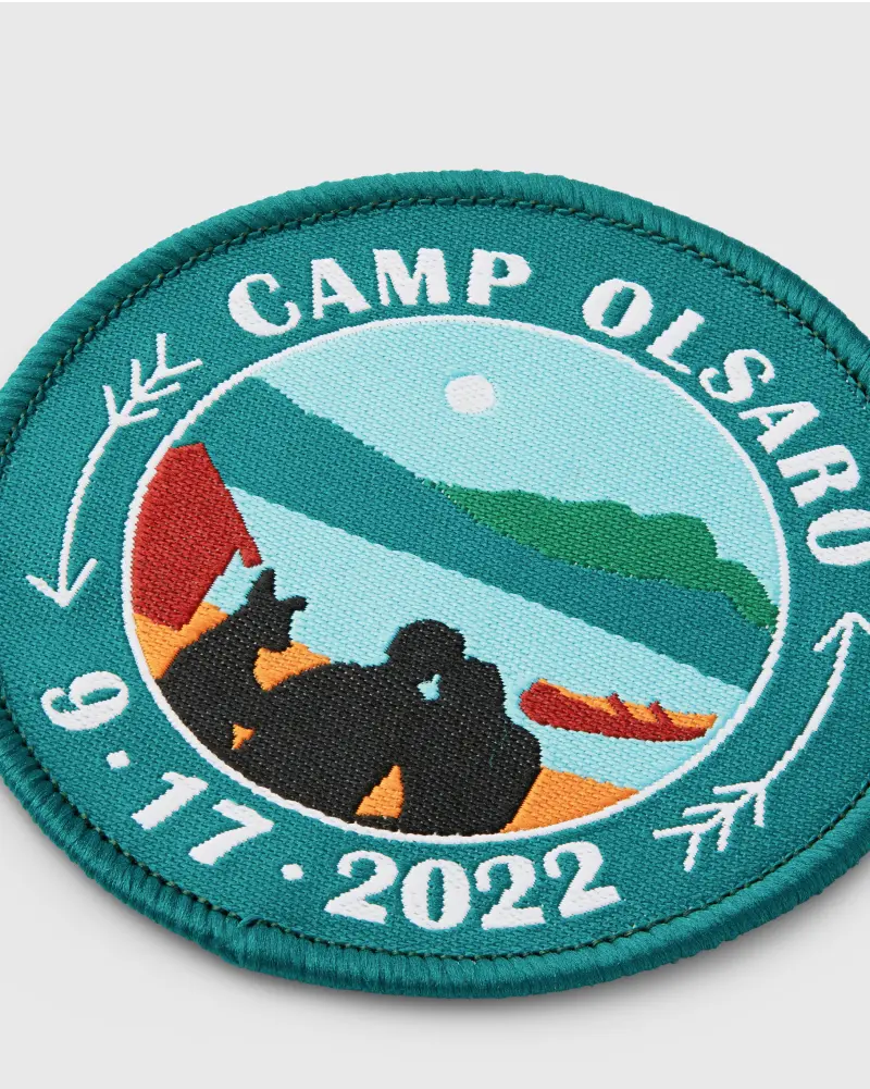 Woven patch with “Camp Olsaro” featuring a lake and canoe.