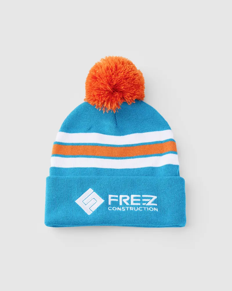 Blue beanie with orange pompom featuring a logo on the front.