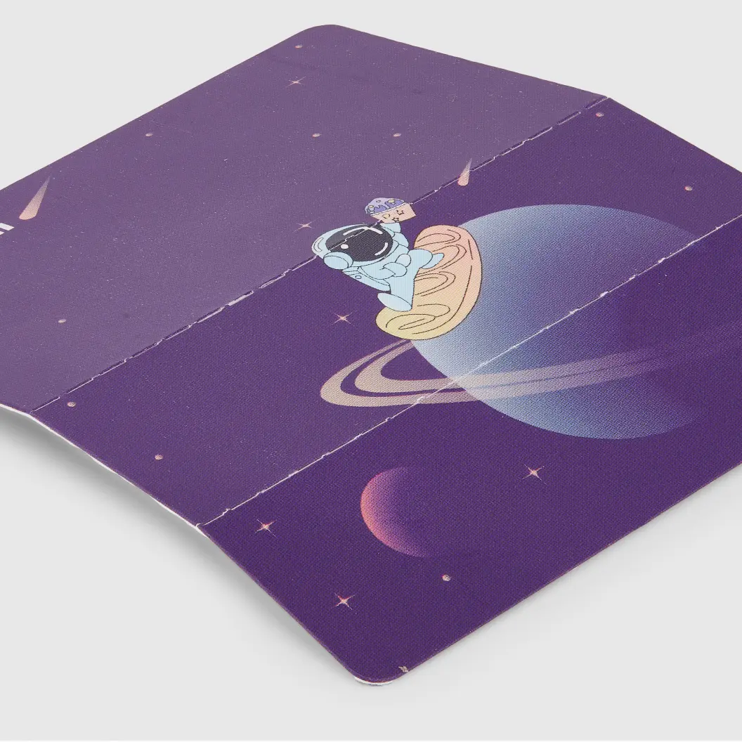 Folded backer card with astronaut and spaceship illustration on a purple background with planets and stars.