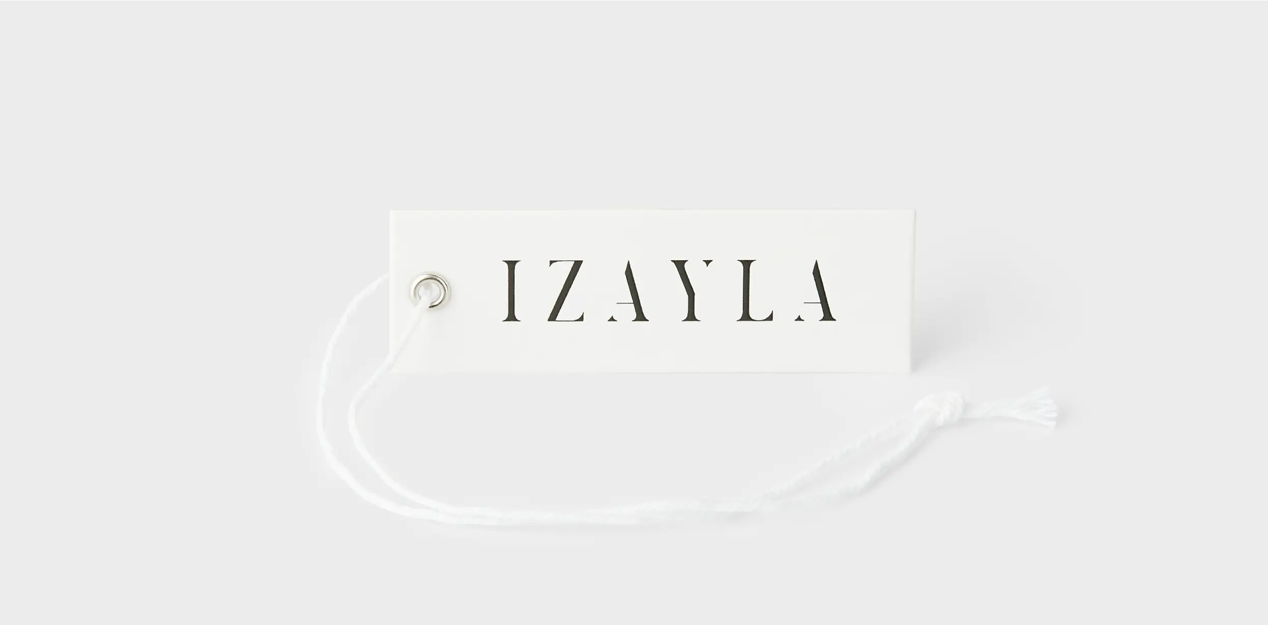 Minimalistic rectangular hang tag with bold, serif letters spelling “IZAYLA” and a white string attached through a metal grommet.