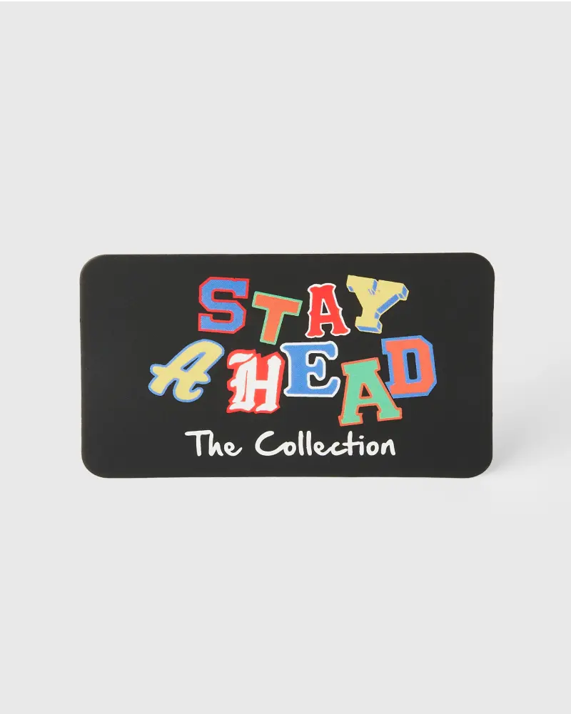 Rectangular black backer card with colorful, playful lettering spelling “Stay Ahead,” accompanied by the text “The Collection.”