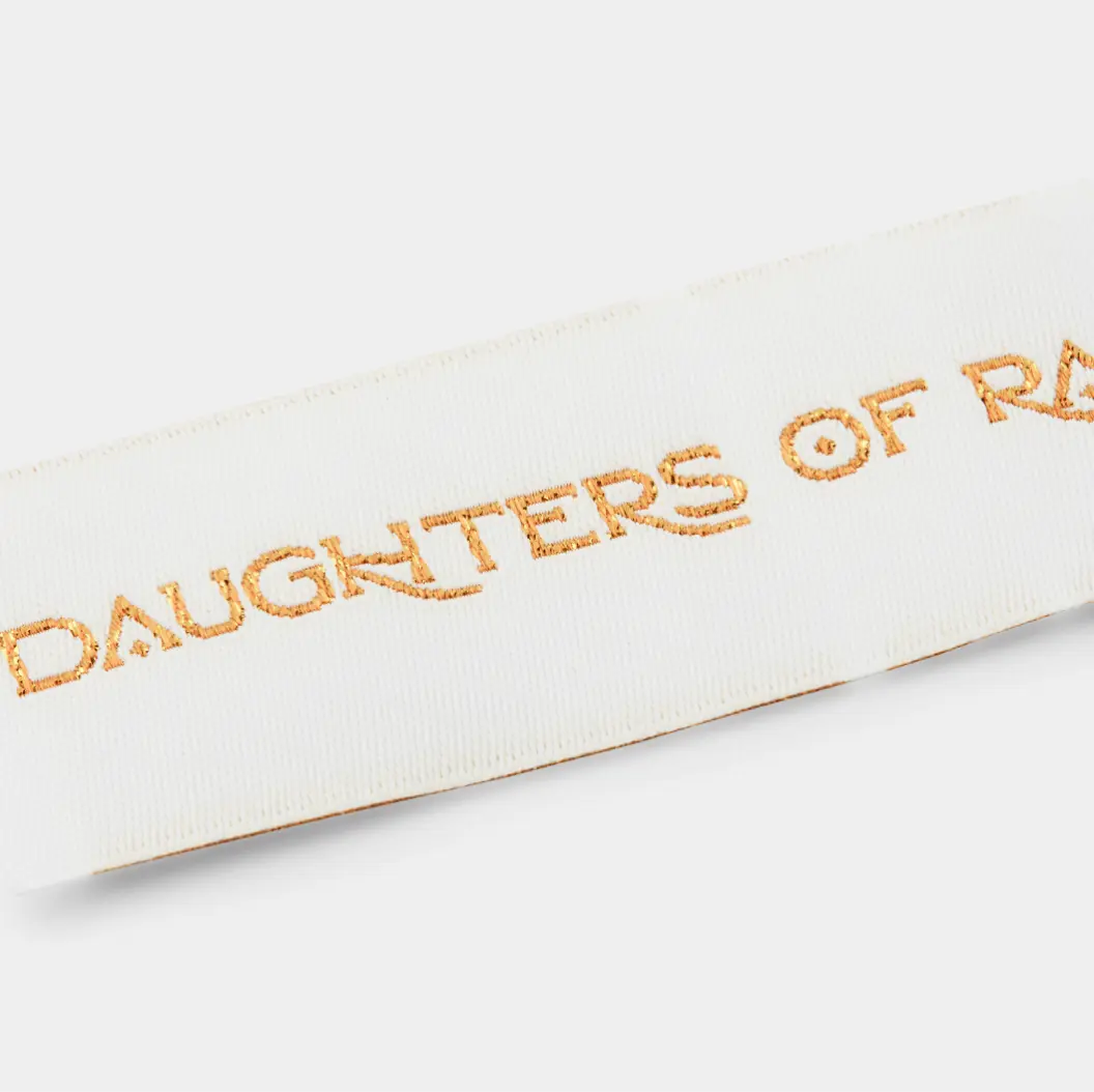 Elegant white woven label with a gold sign.