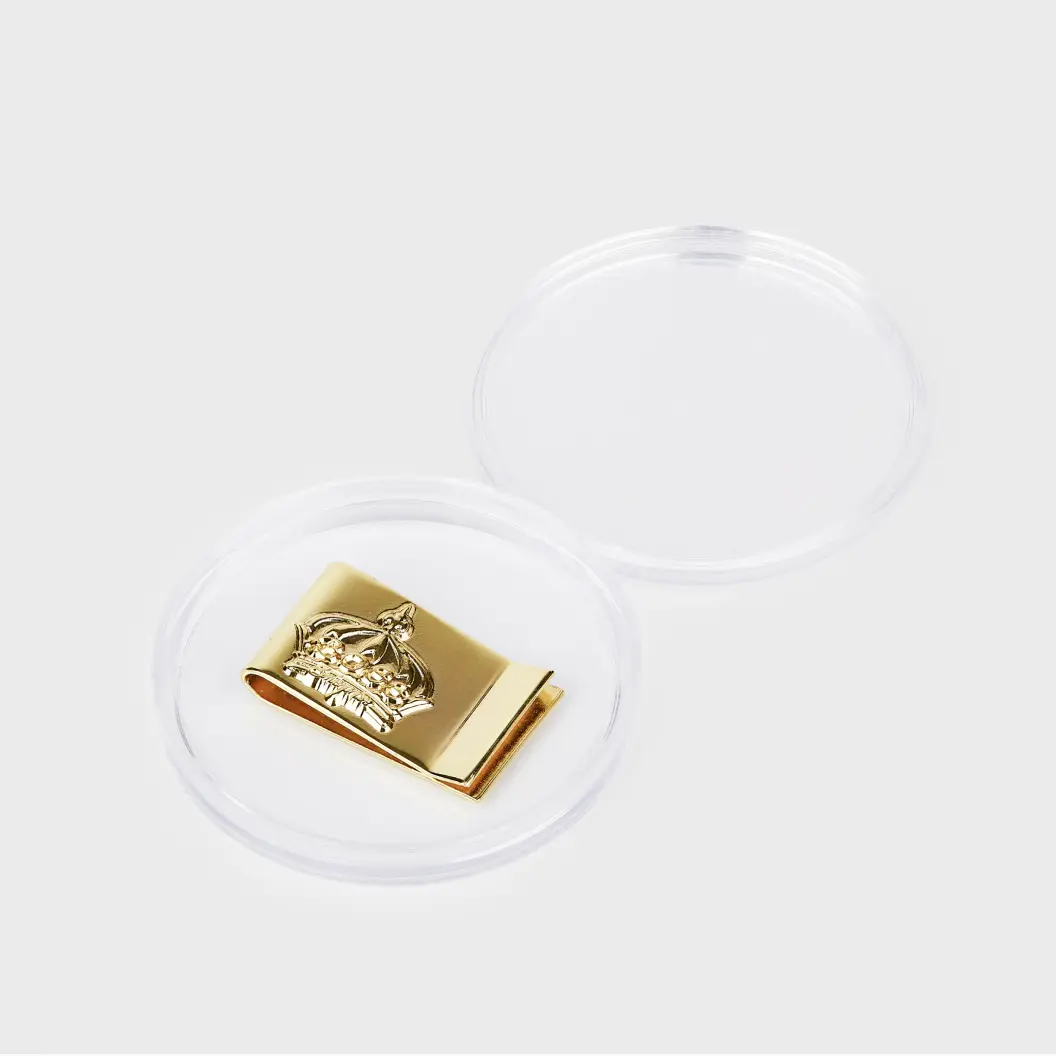 Gold metalic money clip displayed in a transparent acrylic case, highlighting an attractive packaging option.