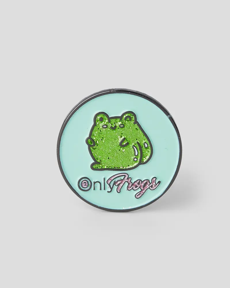 Circular green enamel pin featuring a frog illustration.