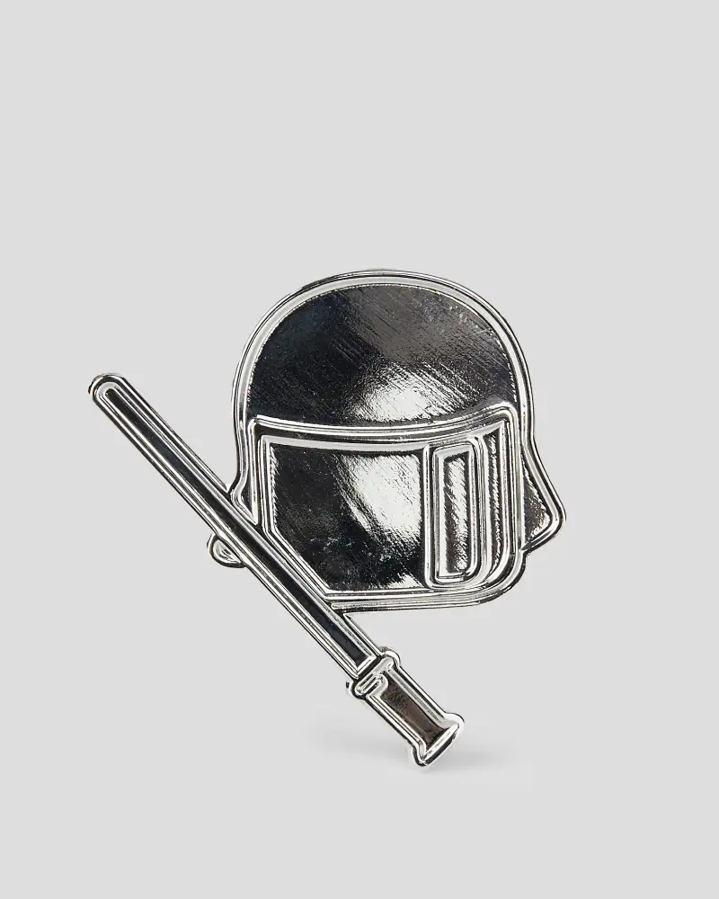 Silver die-struck pin featuring a helmet and baton design with intricate metallic details.