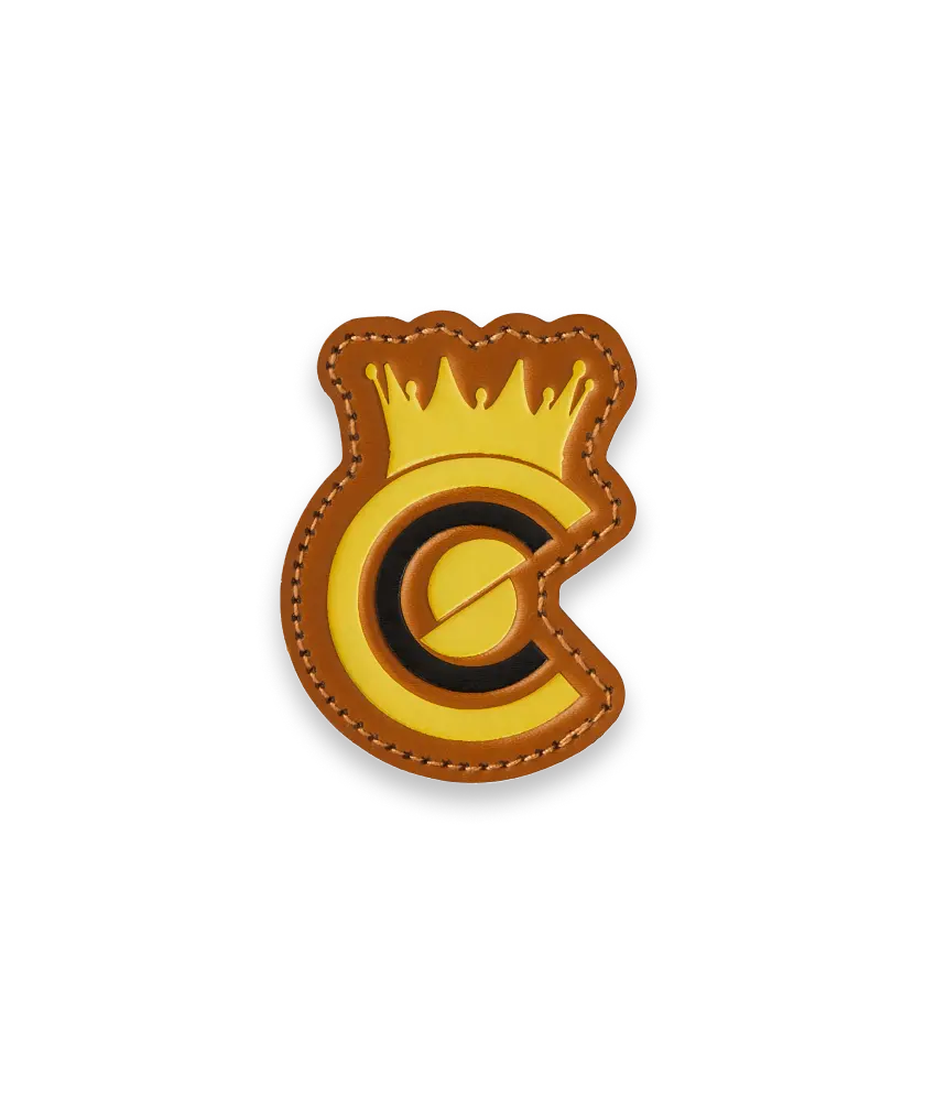 Custom yellow and brown leather patch in the shape of a crown logo.