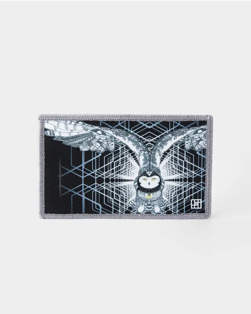 A rectangular patch with an intricate owl design in black and white with geometric background patterns.