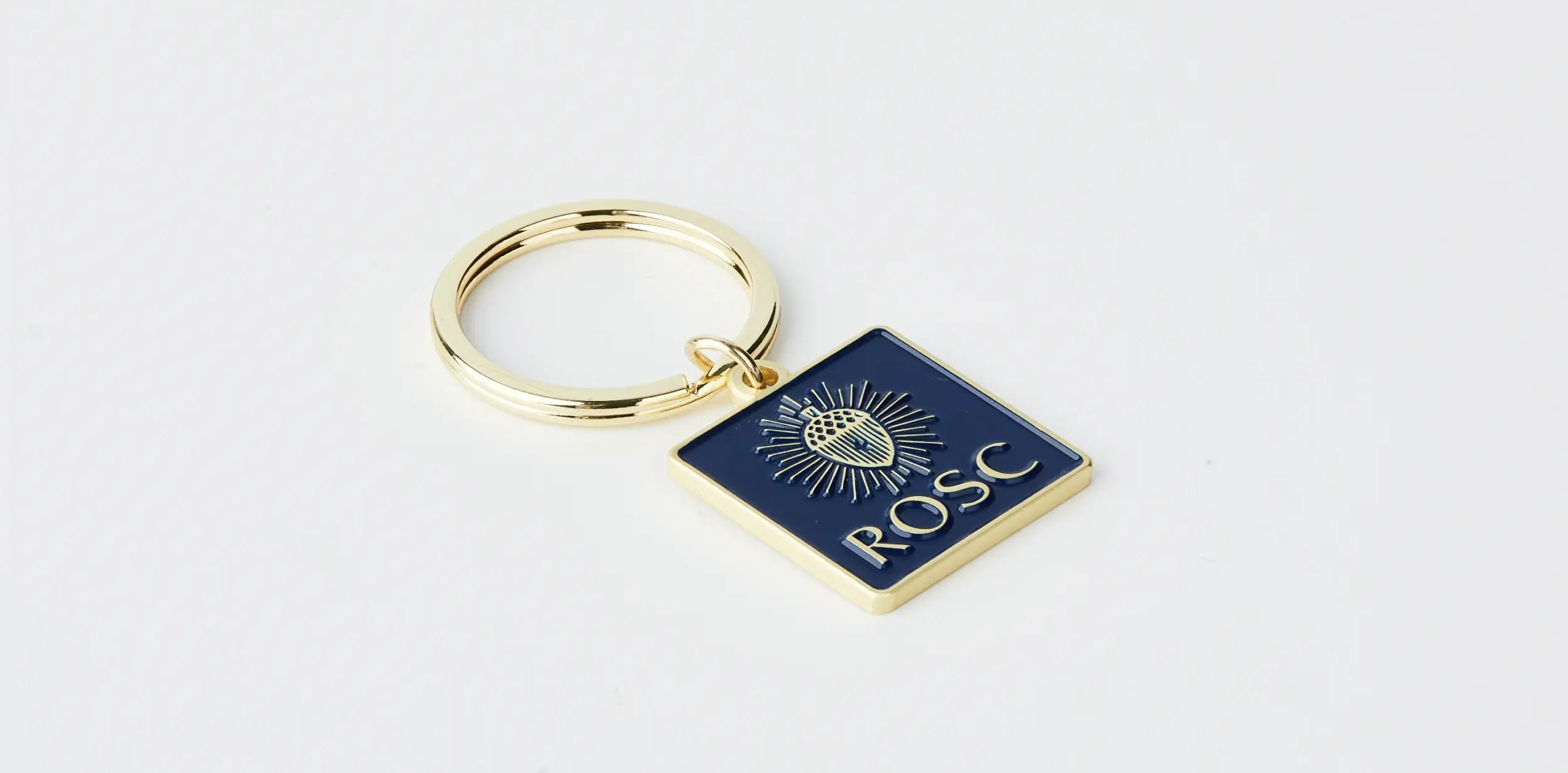 Luxury custom gold metal keychain with blue enamel, acorn motif, and the text ‘ROSC.’