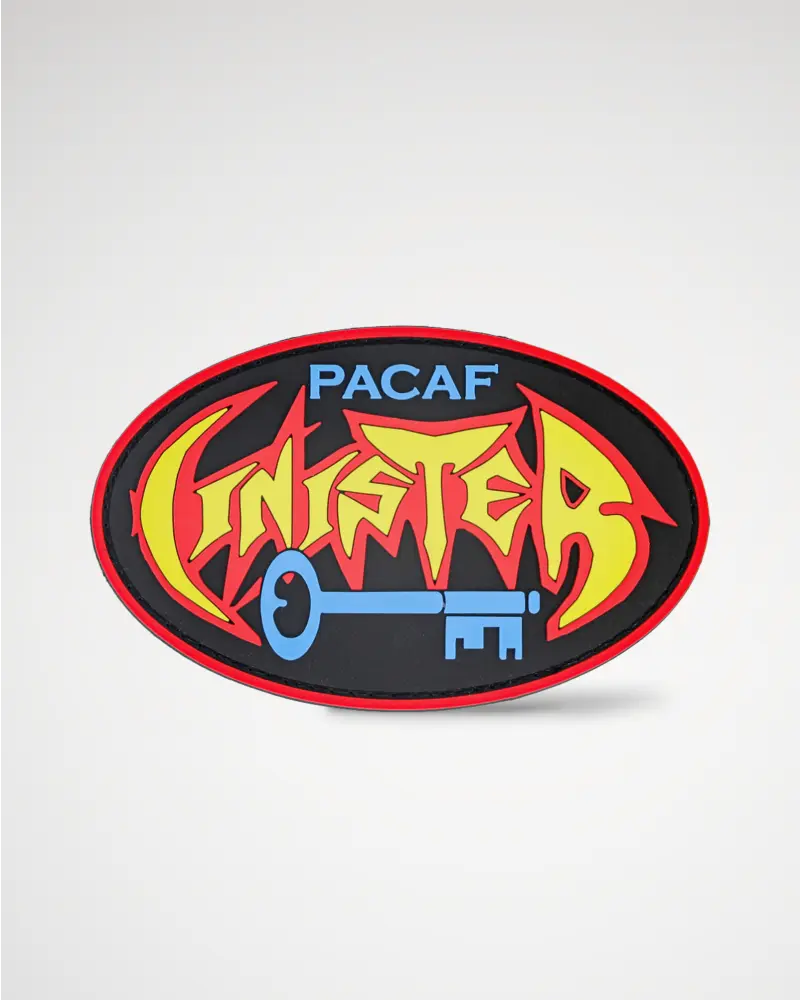 Vibrant graffiti-style PVC patch in black, red, yellow, and blue with “Pacaf Cinister” text and a key.