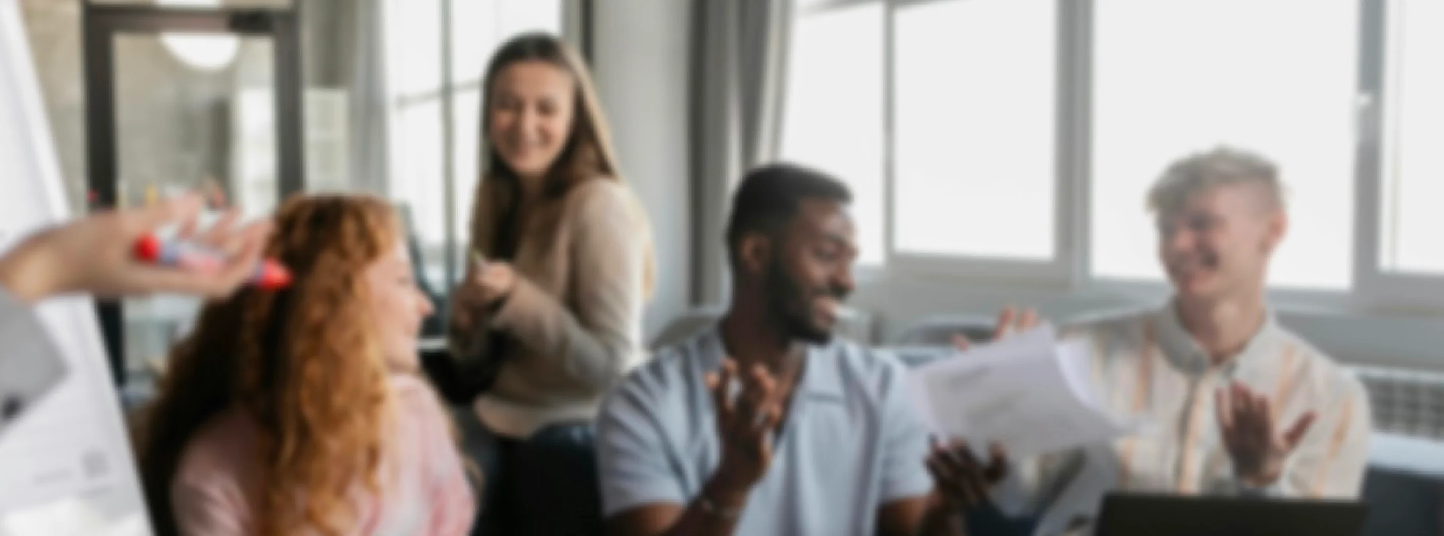 Blurred image of a diverse team engaged in a collaborative meeting