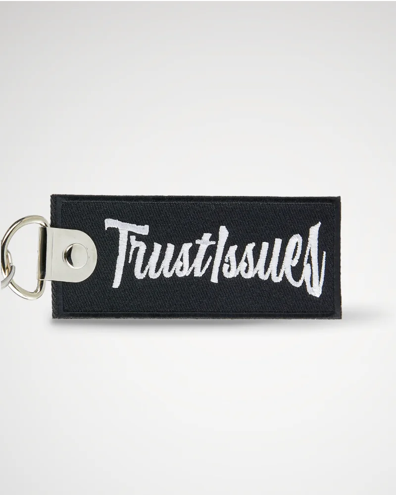 Custom black embroidered keychain featuring intricate stitching and a sleek, minimalist design.