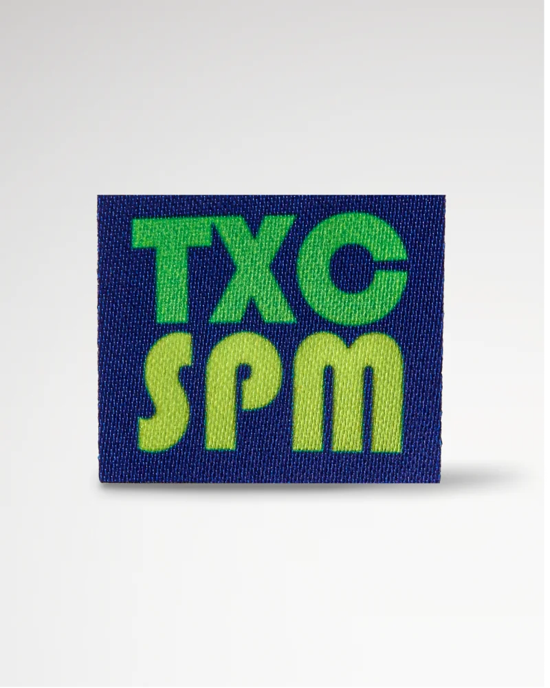 Printed label in dark blue featuring 'TXC SPM' text, designed for a modern and professional look.