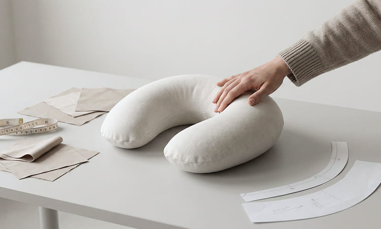 Memory foam neck pillow undergoing ergonomic shape inspection and finishing review